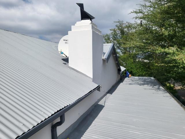 Coated corrugated roof beside a chimney