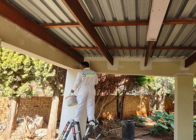 Painter working on a patio ceiling